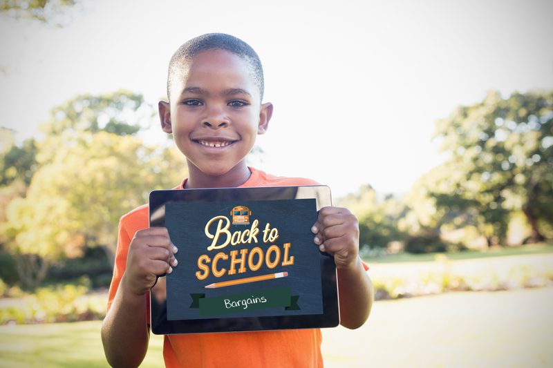 little boy holding a back to school sign
